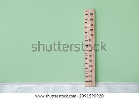 Wooden stadiometer near color wall