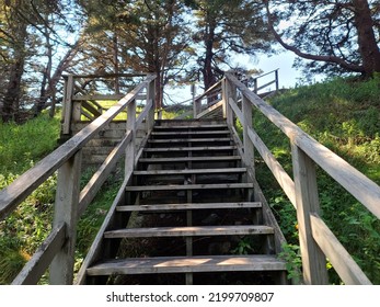 A Wooden Staircase Extending Far Up A Grass Hillside On A Sunny Day.