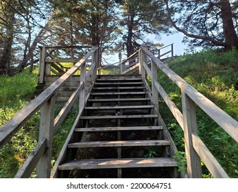 A Wooden Staircase Extending Far Up A Grass Hillside On A Sunny Day.