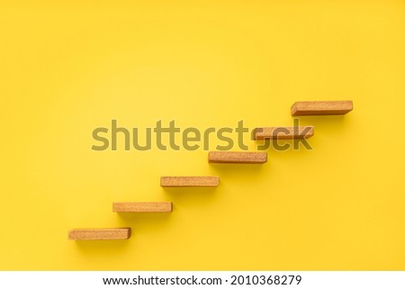 Wooden staircase on yellow background. Growth, increasing business, success process concept. Copy space