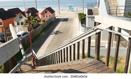 Wooden stairs, beach access in Oceanside, California USA. Coastal stairway, pacific ocean, cottages and lifeguard tower. Vacations in United States. Sunny tropical day, summertime aesthetic. Staircase