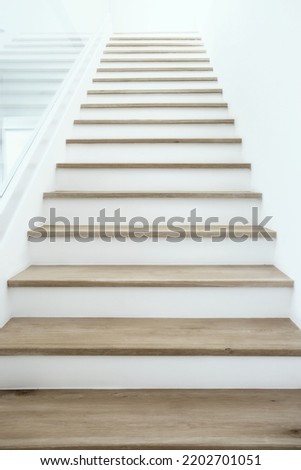 Wooden stairs with clean white walls.