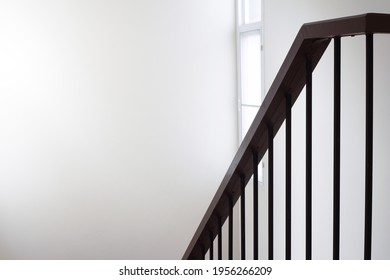 wooden stairs handrail and black steel banister in modern and minimal style with white wall of staircase hall  ,top view from upstairs , selective focus
