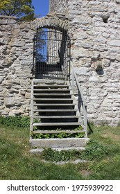 Wooden Stairs Leading Up To A Black Iron Gate In A Stone Wall In Visby, Gotland, Sweden