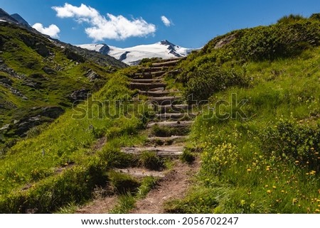 Wooden stairway heading towards Schlatenkees Glacier, located in the Austrian Alps (Tirol). To visit the glacier, it is needed to walk 10 km from Innergschlöß. Großvenediger peak can also be seen.