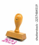 Wooden stamp with the imprint 2023 against a white background