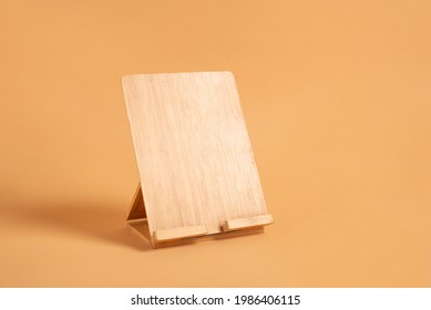 Wooden Stand For A Book Or Ipad On A Beige Background With A Place For Text. сookbook Stand