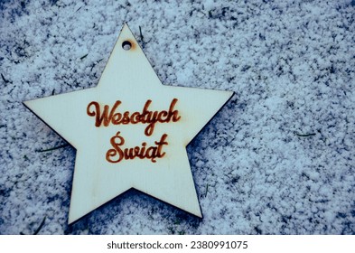 a wooden star with a burnt Polish inscription "Wesołych Świąt" which means "Merry Christmas" on white background - Powered by Shutterstock