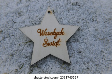 a wooden star with a burnt Polish inscription "Wesołych Świąt" which means "Merry Christmas" on white background - Powered by Shutterstock