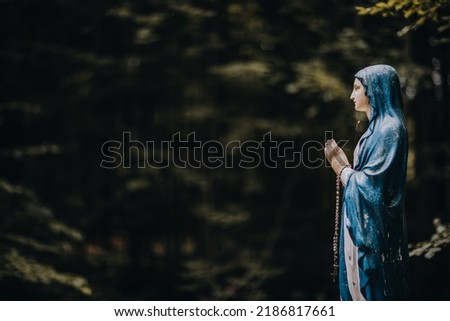 wooden statue of the Virgin Mary in the forest 