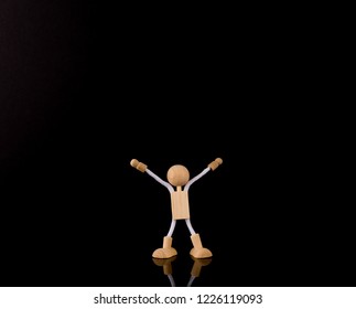 Wooden Stick Figure Arms Up, Isolated On Black Background, Copy Space