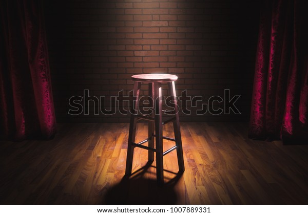 wooden stool on a stand up comedy stage with\
reflectors ray, high contrast\
image