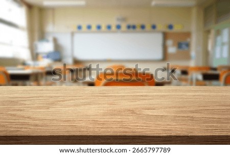The wooden surface is in focus while the classroom behind remains blurred, showcasing empty desks and an inviting atmosphere for learning during school hours.