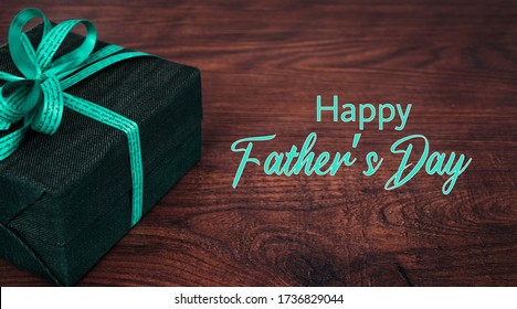 Wooden Surface With A Gift And The Text: Happy Fathers Day. Greeting Card, Banner Or Poster For Father's Day. Photo With Commercial Letters And The Text For Father's Day. Copy Space.