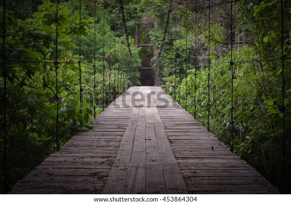 the wooden suspension bridge in nature.\
walkway through the treetops in a rain\
forest.