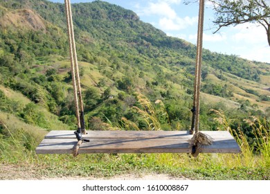 

Wooden Swing With Rope Swing, Behind The Mountains And Sky. Swings With No People Sit.