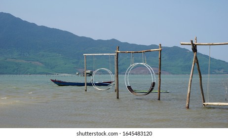 Wooden Swing With Rope Swing, Behind The Mountains And Sea. Swings With No People Sit.

