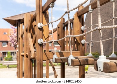 Wooden Swing Set With A Rope And Climbing Equipment On A Childrens Playground In Eindhoven, The Netherlands. Friendly Rounded Construction Shapes For Kids