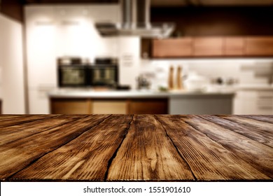 Wooden Table Background Of Free Space For Your Decoration And Blurred Background Of Kitchen. Copy Space.Dark Mood Interior. Kitchen Furniture. 