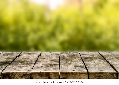 Wooden table or bench on green blurred background. Outdoors - Powered by Shutterstock