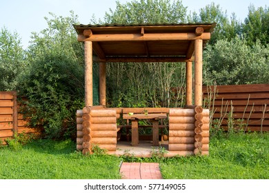 Wooden Table And Benches In A Log Arbor