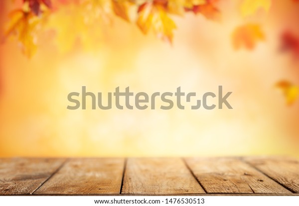 木のテーブルとぼかした秋の背景 赤い黄色の葉の背景に秋のコンセプト の写真素材 今すぐ編集