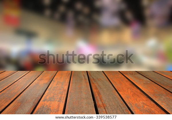 Wooden table and blurred image of motor\
show,show room,motor expo for\
background