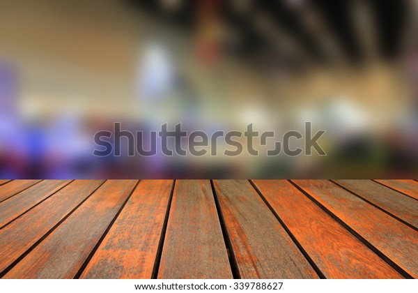Wooden table and blurred image of motor
show,show room,motor expo for
background