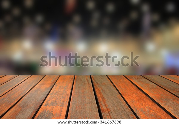 Wooden table and blurred image of motor
show,show room,motor expo for
background