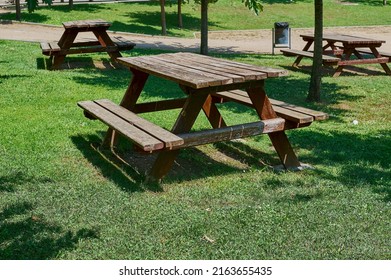 Wooden table and chairs for a picnic in the middle of a city park.