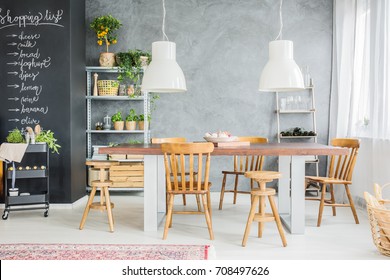 Wooden Table And Chalkboard Wall In Stylish Dining Room Interior