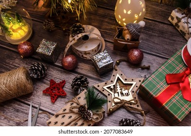 wooden table with Christmas decorations, ribbons and gifts