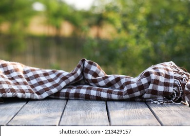 Wooden Table With Cloth On Bright Background