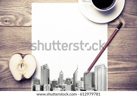 Wooden table with coffee cup and architectural sketches on notepad