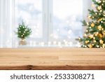 Wooden table for display products with blurred Christmas tree and window interior background