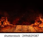 wooden table with Fire burning at the edge of the table, fire particles, sparks, and smoke in the air, with fire flames on a dark background to display products	