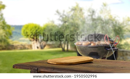 Wooden table of free space and grill in garden 