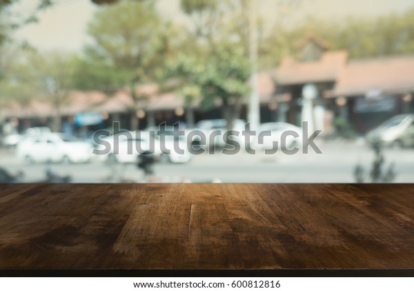 Wooden table in front of abstract\
blurred background of car park lights. can be used for display or\
montage your products.Mock up for display of\
product