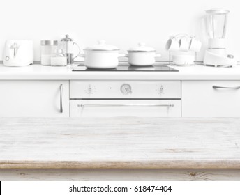 Wooden Table In Front Of Blurred White Kitchen Bench Interior