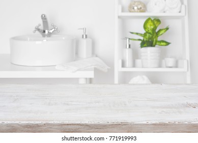 Wooden table in front of blurred white bathroom shelves background - Shutterstock ID 771919993