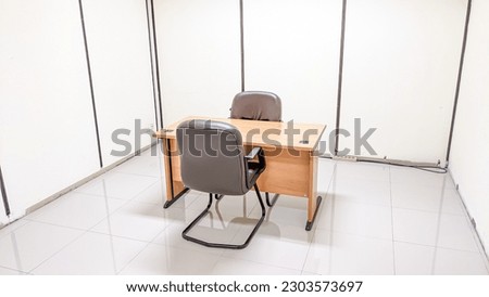 Wooden table furniture and two modern armchairs in the interrogation room