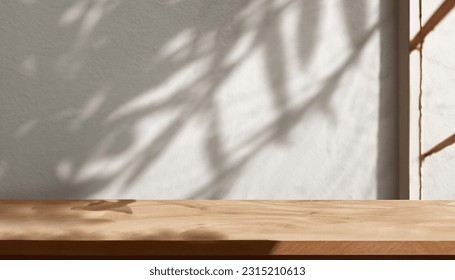 Wooden table mockup and plaster wall background with window and leaves shadow on the wall - Powered by Shutterstock