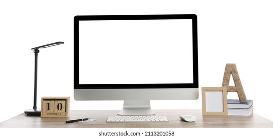 Wooden table with modern computer, decor and stationery on white background