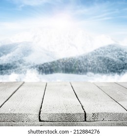 Wooden Table With Mountainous Winter Background.