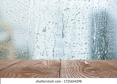 Wooden table near window on rainy day