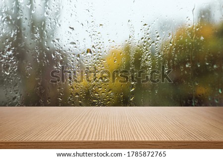Wooden table near window on rainy day 商業照片 © 