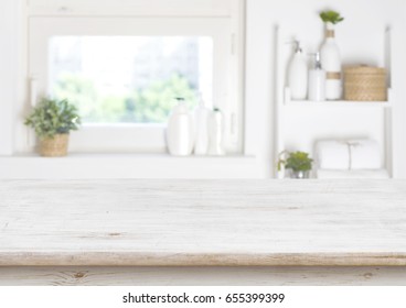 Wooden table on blurred background of bathroom window and shelves