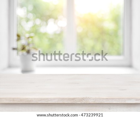 Wooden table on defocused summer window with flower pot background