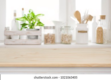 Wooden table over blurred kitchen window sill for product display