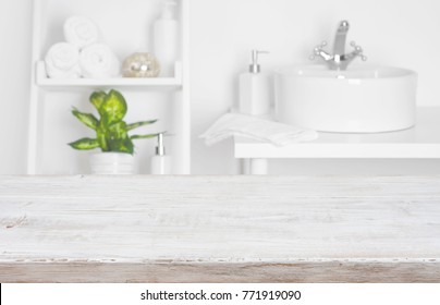 Wooden table over blurred spa salon bathroom shelves background